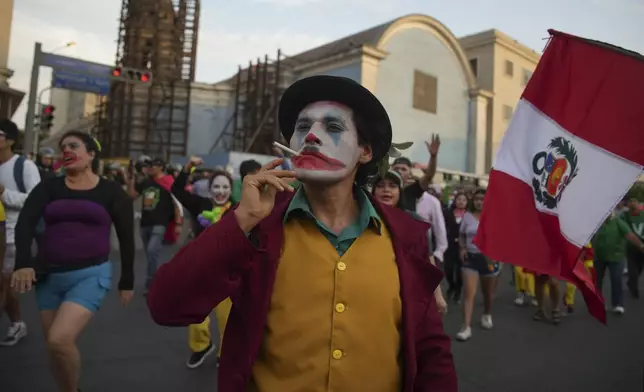 A protester in a Joker costume takes part in a demonstration demanding the government provide security against the rising violence, in Lima, Peru, Friday, March 21, 2025. (AP Photo/Guadalupe Pardo)