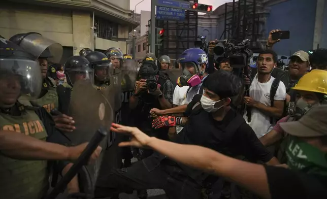 Anti-government protesters clash with police during a march to demand the government provide security against the rising violence in Lima, Peru, Friday, March 21, 2025. (AP Photo/Guadalupe Pardo)