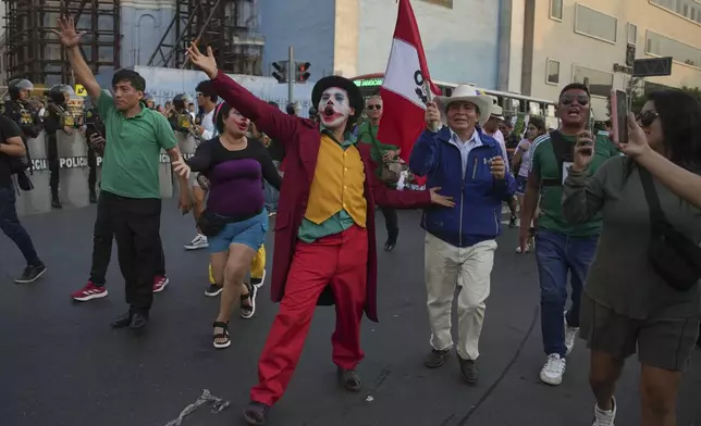 A protester in a Joker costume takes part in a demonstration demanding the government provide security against the rising violence, in Lima, Peru, Friday, March 21, 2025. (AP Photo/Guadalupe Pardo)