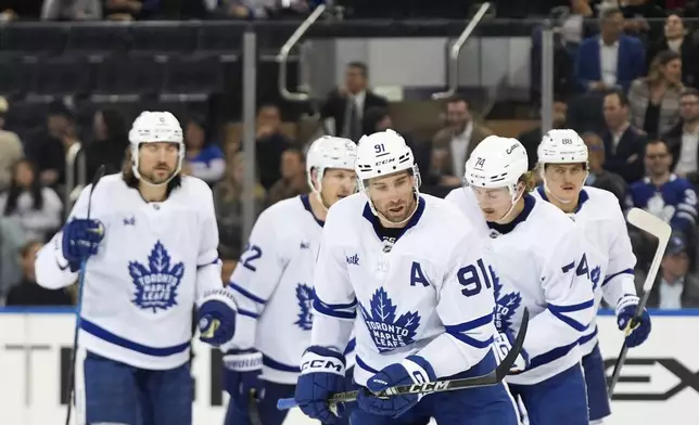 Toronto Maple Leafs defenseman Chris Tanev (8), defenseman Jake McCabe (22), right wing William Nylander (88), center Bobby McMann (74) and center John Tavares (91) skate toward the bench after Tavares scored during the second period of an NHL hockey game against the New York Rangers, Thursday, March 20, 2025, in New York. (AP Photo/Julia Demaree Nikhinson)
