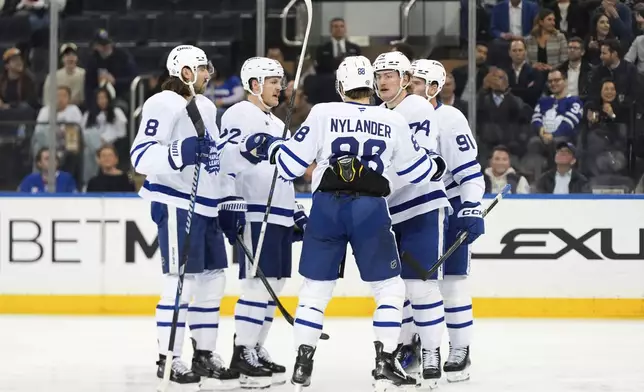 Toronto Maple Leafs defenseman Chris Tanev (8), defenseman Jake McCabe (22), right wing William Nylander (88), center Bobby McMann (74) and center John Tavares (91) huddle after Tavares scored during the second period of an NHL hockey game against the New York Rangers Thursday, March 20, 2025, in New York. (AP Photo/Julia Demaree Nikhinson)