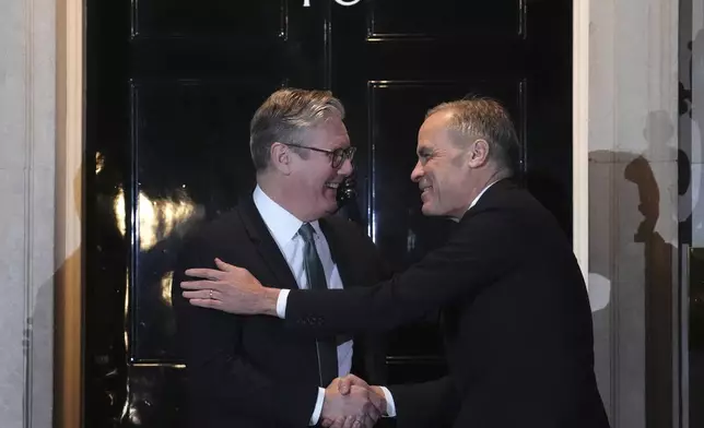 Canada Prime Minister Mark Carney is greeted by British Prime Minister Keir Starmer as he arrives in London on Monday, March 17, 2025. (Sean Kilpatrick/The Canadian Press via AP)