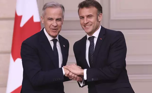 French President Emmanuel Macron, right, and Canada's Prime Minister Mark Carney shake hands after a joint statement Monday, March 17, 2025 at the Elysee Palace in Paris. (AP Photo/Thomas Padilla; Pool)