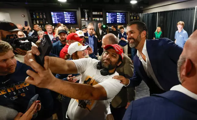 Donald Trump Jr. takes photos with supporters after a town hall meeting Monday, March 17, 2025, in Oconomowoc, Wis. (AP Photo/Jeffrey Phelps)
