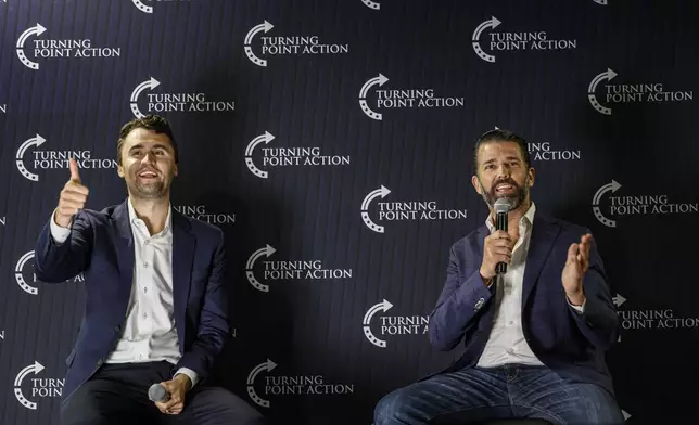 Charlie Kirk, left and Donald Trump Jr., take part in a town hall meeting Monday, March 17, 2025, in Oconomowoc, Wis. (AP Photo/Jeffrey Phelps)