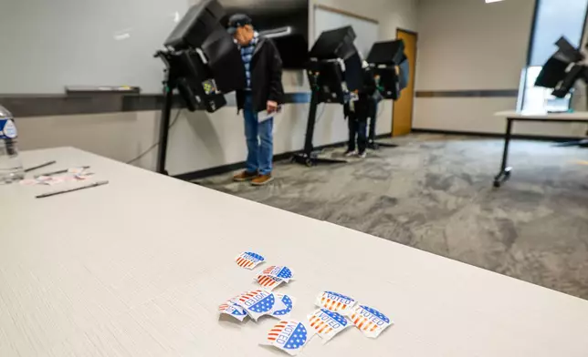 Stickers on a table as people cast ballots during early voting in Waukesha, Wis., Tuesday, March 18, 2025. (AP Photo/Jeffrey Phelps)