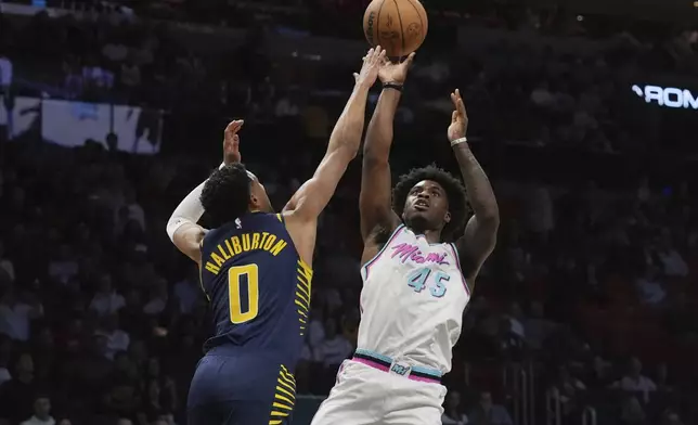 Miami Heat guard Davion Mitchell (45) aims to score as Indiana Pacers guard Tyrese Haliburton (0) defends during the first half of an NBA basketball game, Friday, Feb. 28, 2025, in Miami. (AP Photo/Marta Lavandier)