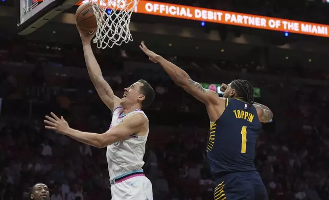 Miami Heat forward Duncan Robinson (55) drives to the basket as Indiana Pacers forward Obi Toppin (1) defends during the first half of an NBA basketball game, Friday, Feb. 28, 2025, in Miami. (AP Photo/Marta Lavandier)
