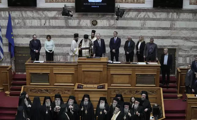 Greece's new President Constantine Tassoulas, top center, takes an oath during the swearing in ceremony at the Parliament, in Athens, Greece, Thursday, March 13, 2025. (AP Photo/Thanassis Stavrakis)