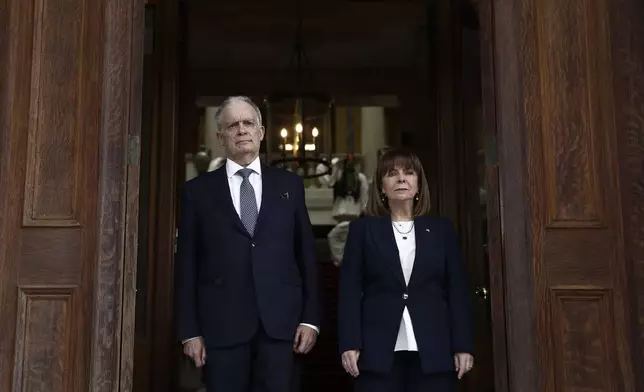 Outgoing Greek President Katerina Sakellaropoulou, right, and the new President Constantine Tassoulas stand for the national anthem during the handover ceremony at the presidential palace in Athens, Greece, Thursday, March 13, 2025. (Yannis Kolesidis/Pool via AP)
