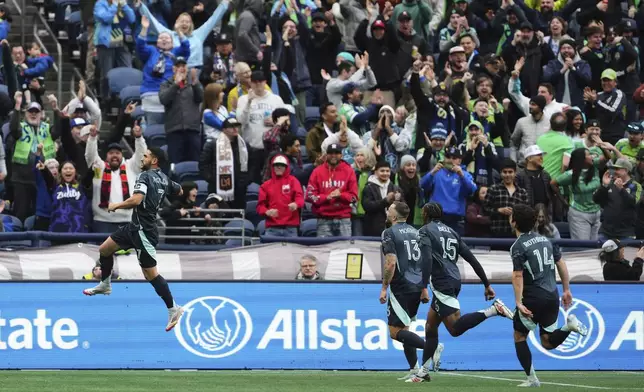 Seattle Sounders midfielder Cristian Roldan, left, jumps up to celebrate his goal against Los Angeles FC with teammates Jordan Morris (13), Jon Bell (15) and Paul Rothrock (14) during the second half of an MLS soccer match Saturday, March 8, 2025, in Seattle. (AP Photo/Lindsey Wasson)