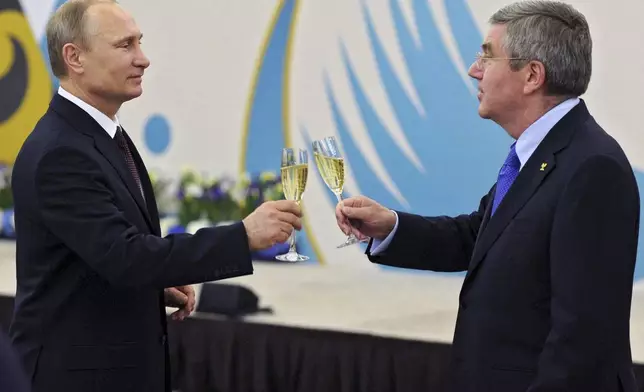 FILE - Russian President Vladimir Putin, left, toasts a glass of champagne with the International Olympic Committee President Thomas Bach during the official reception of IOC for Sochi 2014 Winter Olympics organizing committee on Monday, Feb. 24, 2014, in Sochi, Russia. (AP Photo/RIA Novosti Kremlin, Mikhail Klimentyev, Presidential Press Service, File)