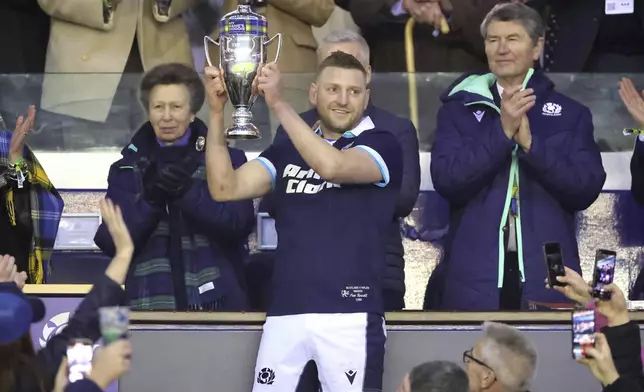 Scotland's Finn Russell lifts the The Doddie Weir Cup following the Men's Six Nations rugby union match the Murrayfield Stadium, Edinburgh, Saturday, March 8, 2025. (Steve Welsh/PA via AP)