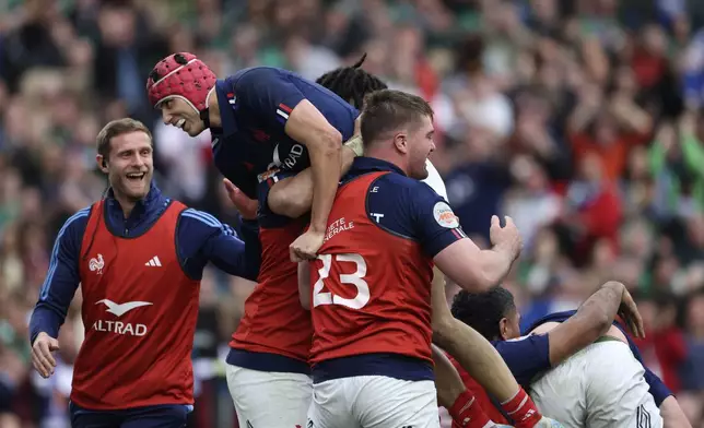 France's Louis Bielle-Biarrey, top, celebrates after his teammate Damian Penaud scored a try during the Six Nations rugby union match between Ireland and France, at Aviva Stadium, Dublin, Ireland, Saturday, March 8, 2025. (AP Photo/Peter Morrison)