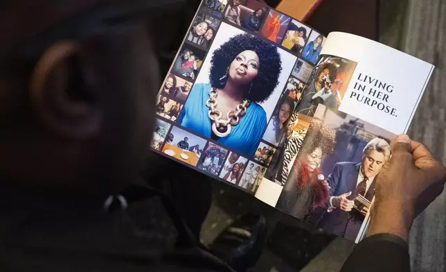 An attendee flips through the program at the memorial service for singer and actress Angie Stone, Friday, March 14, 2025, in Austell. Ga. (AP Photo/Olivia Bowdoin)