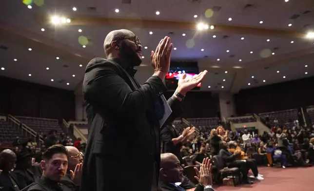 Tyler Perry stands and applauds at the memorial service for singer and actress Angie Stone, Friday, March 14, 2025, in Austell. Ga. (AP Photo/Olivia Bowdoin)