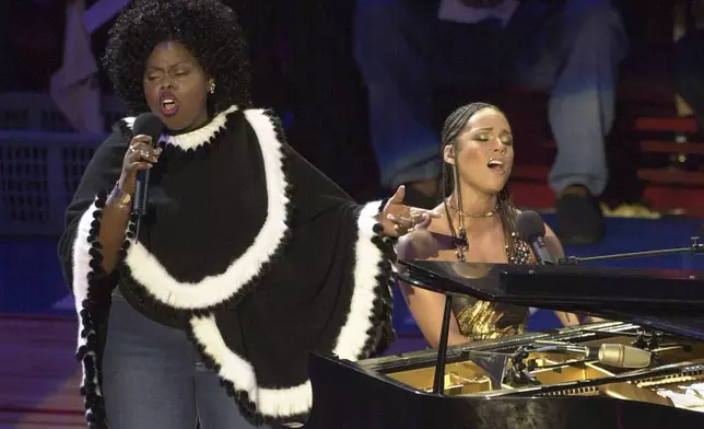 FILE - Alicia Keys, right, and Angie Stone, perform "America the Beautiful" during the NBA All-Star game in Philadelphia, Feb. 10, 2002. (AP Photo/Dan Loh, file)