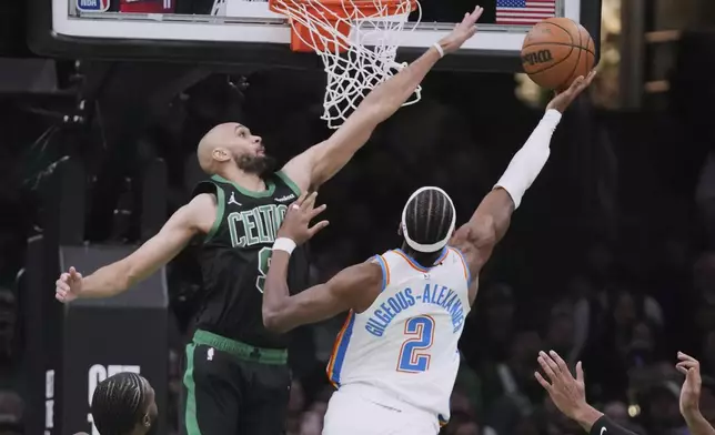 Boston Celtics guard Derrick White, left, tries to block a shot by Oklahoma City Thunder guard Shai Gilgeous-Alexander (2) during the first half of an NBA basketball game, Wednesday, March 12, 2025, in Boston. (AP Photo/Charles Krupa)