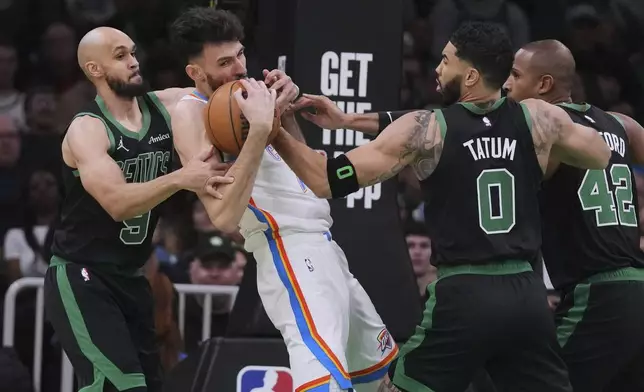 Oklahoma City Thunder forward Chet Holmgren, center, hangs onto the ball while surrounded by Boston Celtics during the first half of an NBA basketball game, Wednesday, March 12, 2025, in Boston. (AP Photo/Charles Krupa)