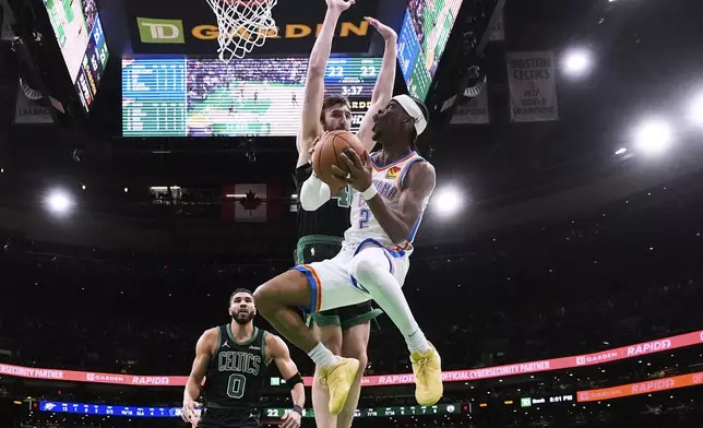 Oklahoma City Thunder guard Shai Gilgeous-Alexander (2) drive to the basket against Boston Celtics center Luke Kornet, rear right, and forward Jayson Tatum (0) during the first half of an NBA basketball game, Wednesday, March 12, 2025, in Boston. (AP Photo/Charles Krupa)