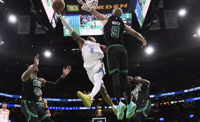 Oklahoma City Thunder guard Shai Gilgeous-Alexander (2) drive to the basket against Boston Celtics guard Derrick White (9) during the first half of an NBA basketball game, Wednesday, March 12, 2025, in Boston. (AP Photo/Charles Krupa)
