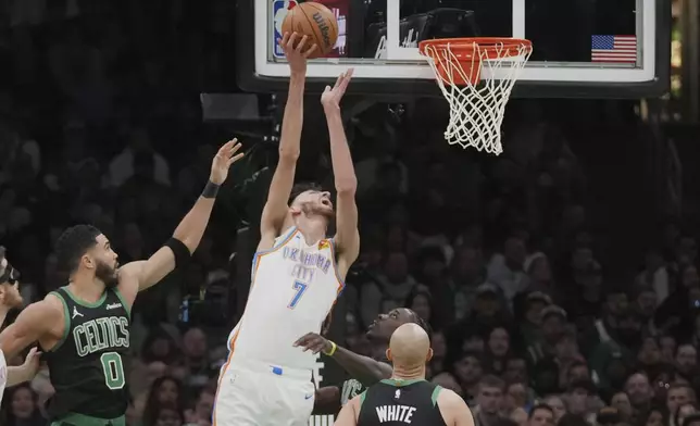 Oklahoma City Thunder forward Chet Holmgren (7) taps in a rebound against Boston Celtics forward Jayson Tatum (0) during the first half of an NBA basketball game, Wednesday, March 12, 2025, in Boston. (AP Photo/Charles Krupa)