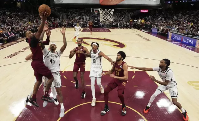 Cleveland Cavaliers guard Darius Garland (10), left, shoots in the second half of an NBA basketball game against the Brooklyn Nets, Tuesday, March 11, 2025, in Cleveland. (AP Photo/Sue Ogrocki)