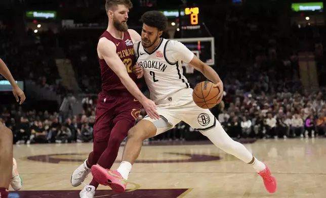 Brooklyn Nets forward Cameron Johnson (2) drives against Cleveland Cavaliers forward Dean Wade (32) in the second half of an NBA basketball game, Tuesday, March 11, 2025, in Cleveland. (AP Photo/Sue Ogrocki)