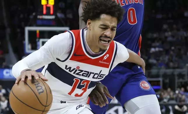 Washington Wizards guard Jordan Poole (13) tries to work around Detroit Pistons center Jalen Duren (0) while going to the basket during the first half of an NBA basketball game Tuesday, March 11, 2025, in Detroit. (AP Photo/Duane Burleson)