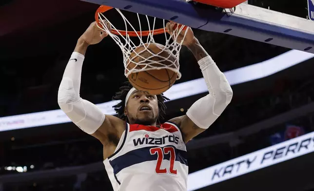 Washington Wizards forward Richaun Holmes (22) dunks the ball against the Detroit Pistons during the first half of an NBA basketball game Tuesday, March 11, 2025, in Detroit. (AP Photo/Duane Burleson)