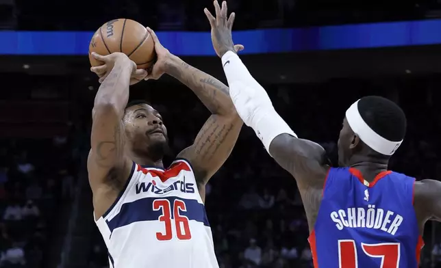 Washington Wizards guard Marcus Smart (36) takes a shot against Detroit Pistons guard Dennis Schroder (17) during the first half of an NBA basketball game Tuesday, March 11, 2025, in Detroit. (AP Photo/Duane Burleson)