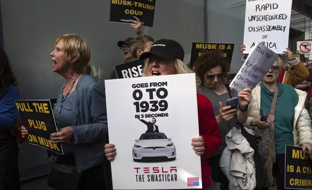 Demonstrators take part in a protest against Elon Musk and Tesla outside of a Tesla showroom, Saturday, March 01, 2025 in New York. (AP Photo/Adam Gray)