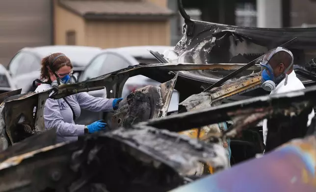 ATF investigators take apart and document a burned Tesla Cybertruck at a Tesla lot in Seattle, Monday, March 10, 2025. (AP Photo/Lindsey Wasson)