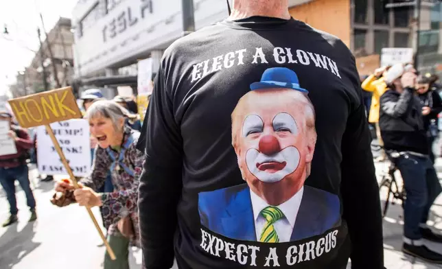 Protesters rally outside a Tesla dealership in San Francisco, Saturday, March 15, 2025. (AP Photo/Josh Edelson)