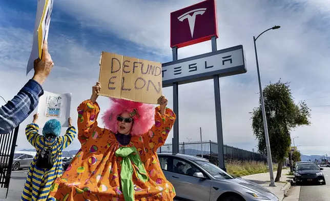 Vanessa Gonzalez joins other protesters carrying signs and chanting slogans outside a Tesla showroom and service center in the North Hollywood section of Los Angeles on Saturday, March 15, 2025. (AP Photo/Richard Vogel)