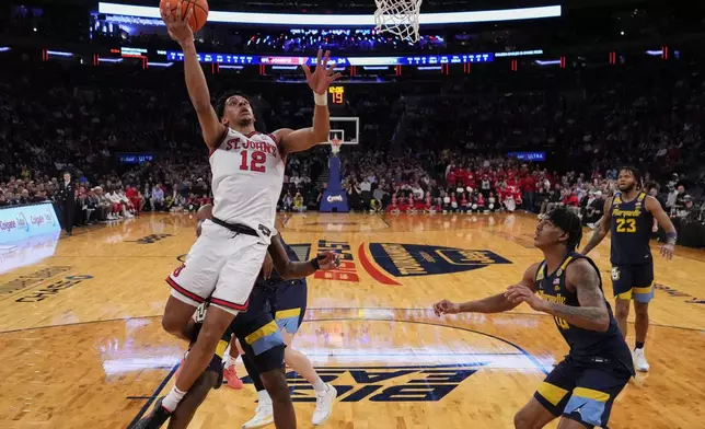St. John's's RJ Luis Jr. (12) drives past Marquette's Damarius Owens (10) and Chase Ross during the first half of an NCAA college basketball game in the semifinals of the Big East tournament Friday, March 14, 2025, in New York. (AP Photo/Frank Franklin II)