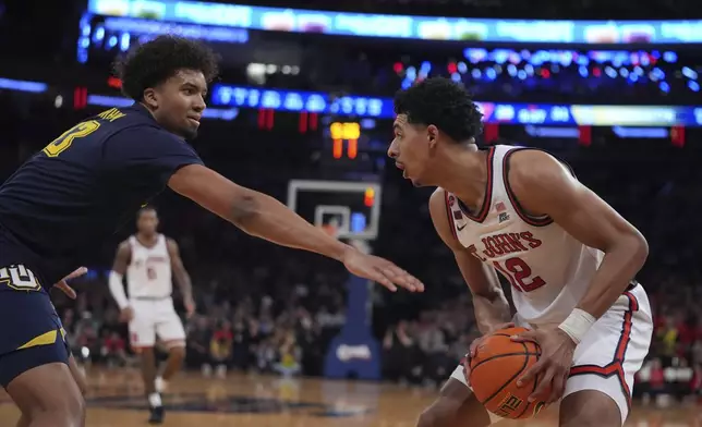 Marquette's Royce Parham, left, defends St. John's's RJ Luis Jr. (12) during the first half of an NCAA college basketball game in the semifinals of the Big East tournament Friday, March 14, 2025, in New York. (AP Photo/Frank Franklin II)