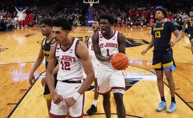 St. John's's Kadary Richmond (1) celebrates after RJ Luis Jr. (12) scored during the first half of an NCAA college basketball game against the Marquette in the semifinals of the Big East tournament Friday, March 14, 2025, in New York. (AP Photo/Frank Franklin II)