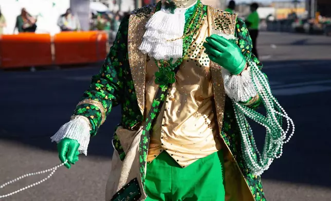 Parade volunteers dressed up as leprechauns toss necklaces at the 22nd Annual World's Shortest St. Patrick's Day Parade on Monday, March 17, 2025, in Hot Springs, Ark. (AP Photo/Katie Adkins)