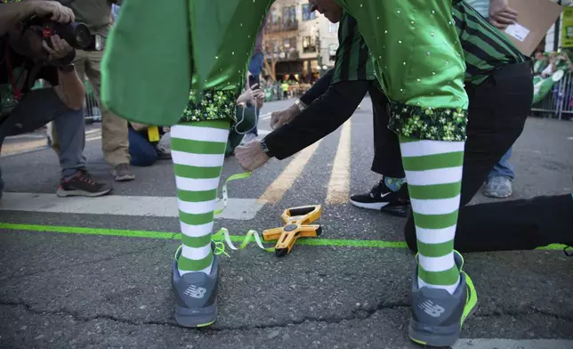 Parade officials measure the route at the 22nd Annual World's Shortest St. Patrick's Day Parade on Monday, March 17, 2025, in Hot Springs, Ark. (AP Photo/Katie Adkins)