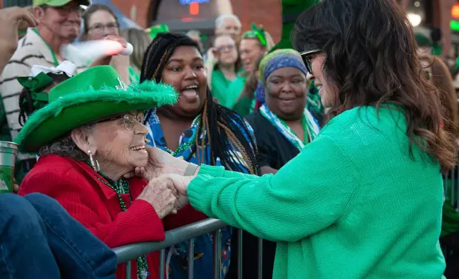 Grand Marshall Valerie Bertinelli, right, greets a woman in the crowd at the 22nd Annual World's Shortest St. Patrick's Day Parade on Monday, March 17, 2025, in Hot Springs, Ark. (AP Photo/Katie Adkins)