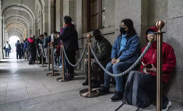 People wait in line outside the Court of Final Appeal in Hong Kong, Thursday, March 6, 2025. Three former organizers of Hong Kong's annual vigil in remembrance of the 1989 Tiananmen Square crackdown won their bid at the top court on Thursday to overturn their conviction over their refusal to provide information to police, marking a rare victory for the city's pro-democracy activists. (AP Photo/Chan Long Hei)