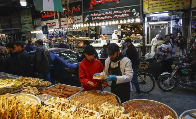 FILE.- A boy buys sweets on the first day of Ramadan, the holy month for Muslims, in Damascus, Syria, Saturday March 1, 2025.(AP Photo/Omar Sanadiki,File)