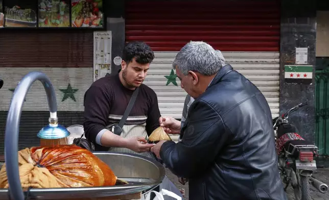 A man buys a traditional cold drink on the first day of Ramadan, the holy month for Muslims, in Damascus, Syria, Saturday March 1, 2025.(AP Photo/Omar Sanadiki)