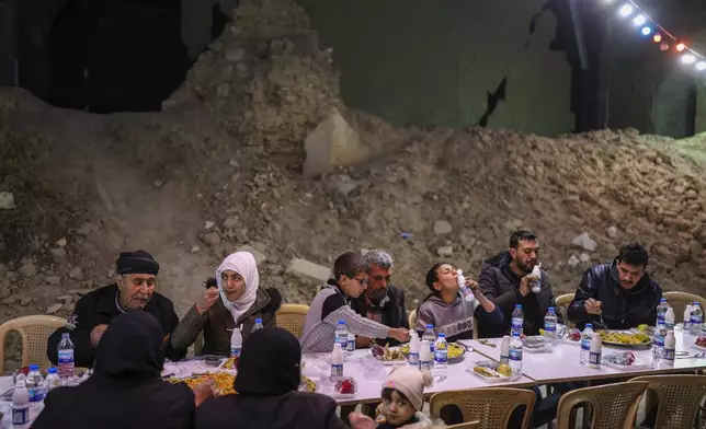 FILE.- Residents gather for the fast-breaking meal known as iftar, organized by the Turkish Humanitarian Relief Foundation (IHH), on the first day of Ramadan in the Jobar neighborhood, which was devastated by the Syrian war, in Damascus, Syria, on Saturday, March 1, 2025.(AP Photo/Ghaith Alsayed,File)