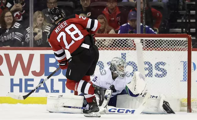 Vancouver Canucks goaltender Thatcher Demko, right, stops a shot by New Jersey Devils right wing Timo Meier (28) during a shootout of an NHL hockey game Monday, March 24, 2025, in Newark, N.J. (AP Photo/Adam Hunger)