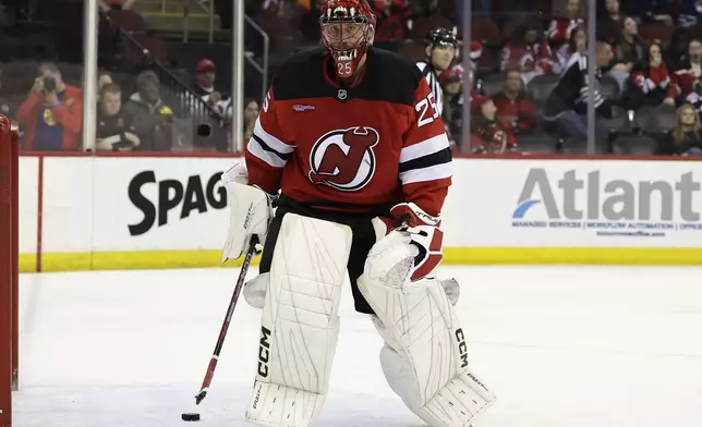 New Jersey Devils goaltender Jacob Markstrom skates off with a broken stick after giving up a goal during a shootout of an NHL hockey game against the Vancouver Canucks, Monday, March 24, 2025, in Newark, N.J. (AP Photo/Adam Hunger)
