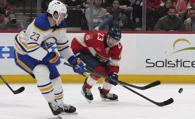 Buffalo Sabres defenseman Mattias Samuelsson (23) and Florida Panthers center Carter Verhaeghe (23), right, go for the puck during the second period of an NHL hockey game, Saturday, March 8, 2025, in Sunrise, Fla. (AP Photo/Lynne Sladky)