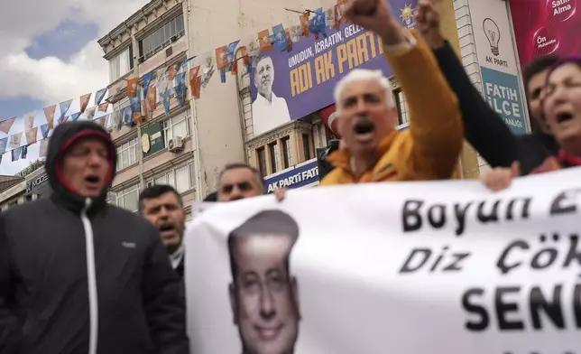 Backdropped by a billboard featuring a photo of Turkey's President Recep Tayyip Erdogan, people chant slogans as they protest outside the Vatan Security Department, where Istanbul Mayor Ekrem Imamoglu is expected to be taken following his arrest in Istanbul, Turkey, Wednesday, March 19, 2025. (AP Photo/Francisco Seco)