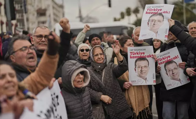 People chant slogans and hold posters of Istanbul Mayor Ekrem Imamoglu as they protest outside the Vatan Security Department, where Imamoglu is expected to be taken following his arrest in Istanbul, Turkey, Wednesday, March 19, 2025. (AP Photo/Francisco Seco)